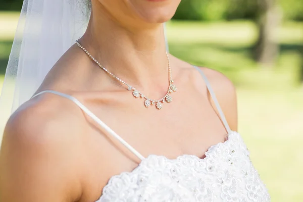 Bride wearing necklace in garden