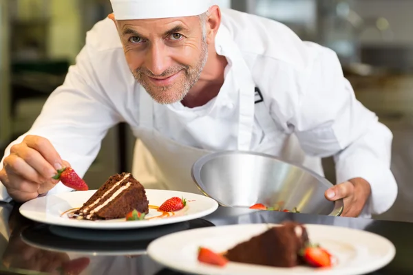 Smiling male pastry chef decorating dessert in kitchen