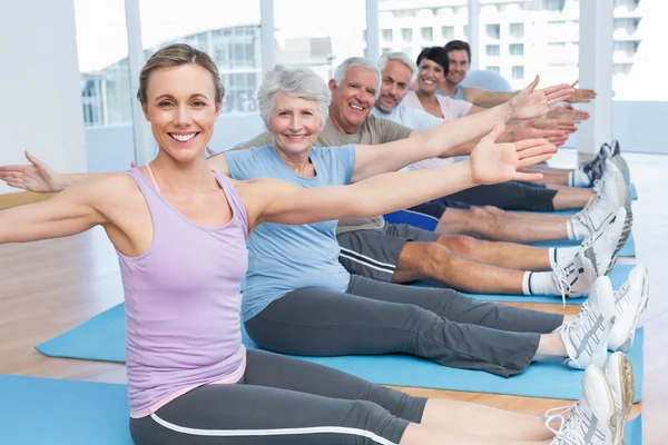 Class stretching hands at yoga class