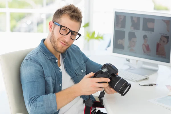 Handsome photographer holding his camera smiling