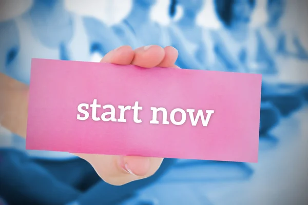 Woman holding pink card saying start now