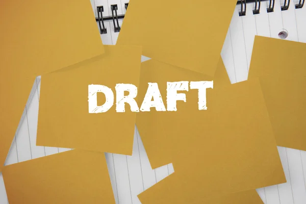Draft against yellow paper strewn over notepad