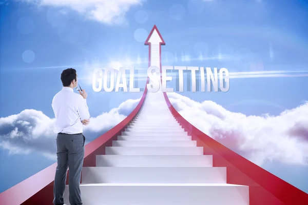 Goal setting against red steps arrow pointing up against sky