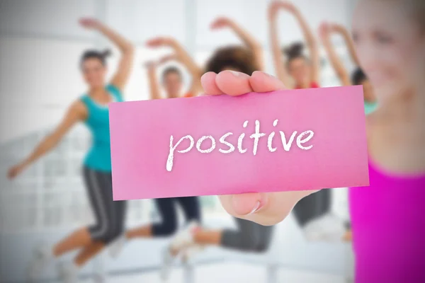 Woman holding pink card saying positive