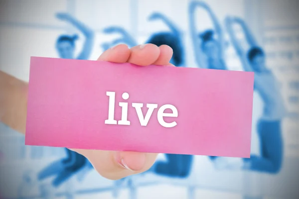 Woman holding pink card saying live