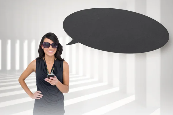 Brunette holding smartphone with speech bubble