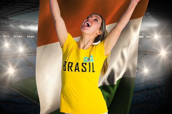 Excited football fan in brasil tshirt holding flag