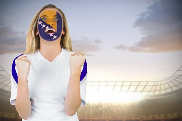 Composite image of excited bosnia fan in face paint cheering