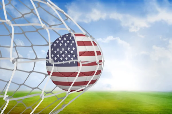 Composite image of football in america colours at back of net