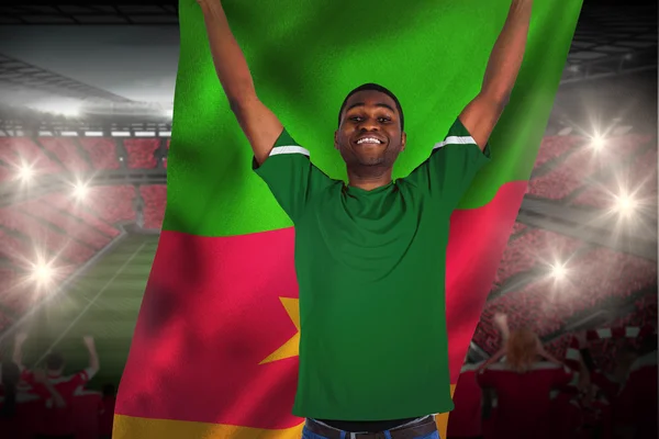 Composite image of cheering football fan in green jersey holding