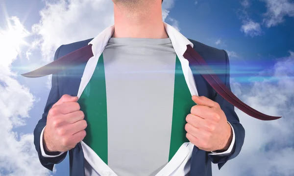 Businessman opening shirt to reveal nigeria flag