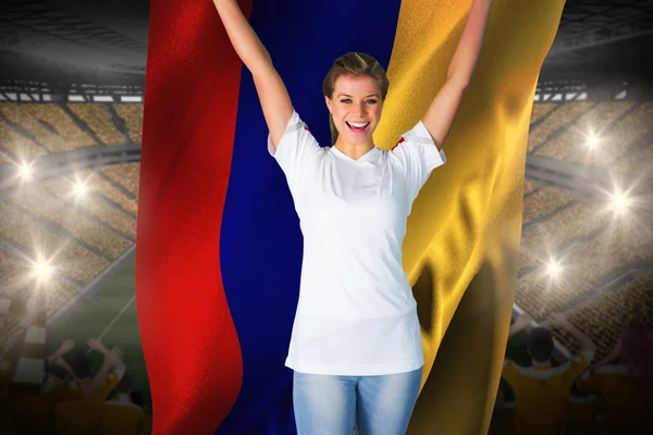 Pretty football fan in white cheering holding flag