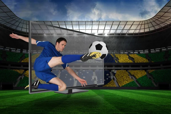 Composite image of football player kicking ball through tv
