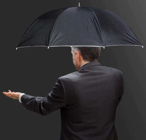 Businessman holding umbrella