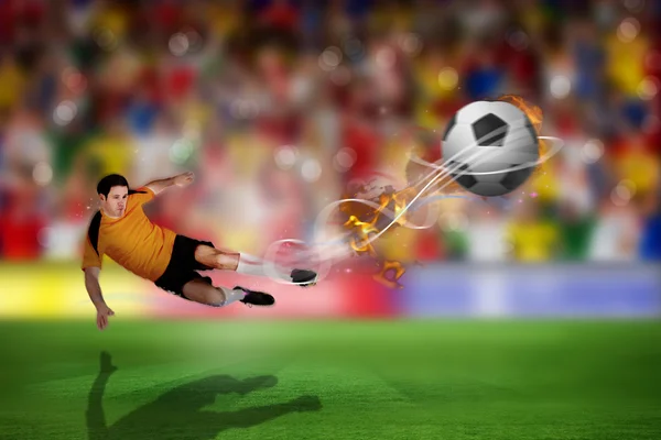Football player in orange kicking
