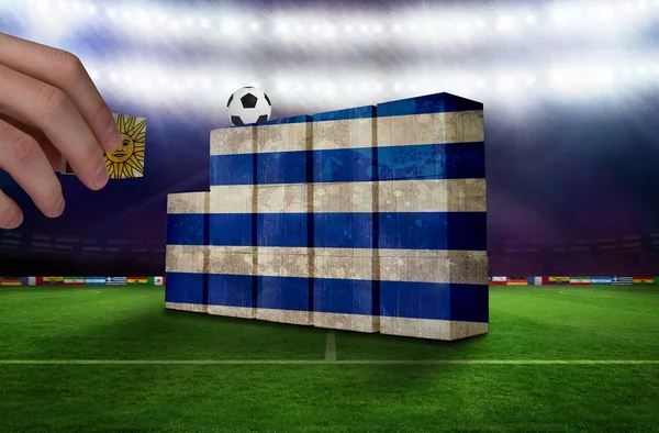 Hand building wall of uruguay flag