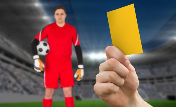 Hand holding up yellow card