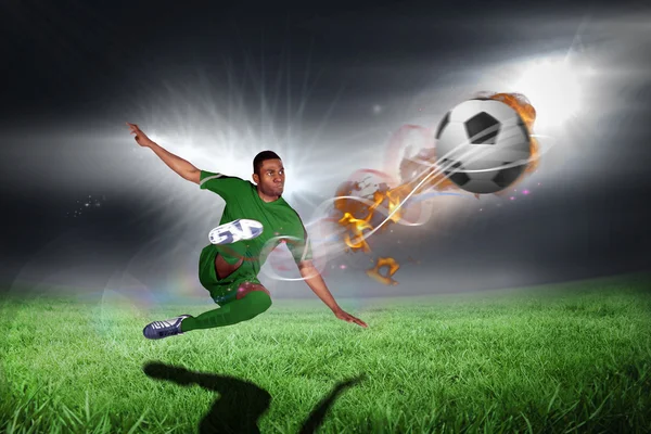 Football player in green kicking