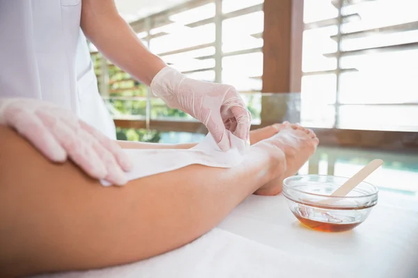 Woman getting her legs waxed
