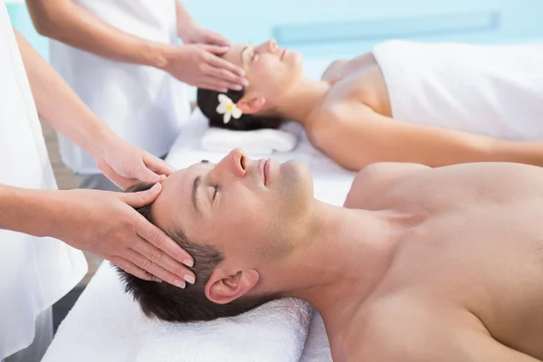 Couple enjoying head massages poolside