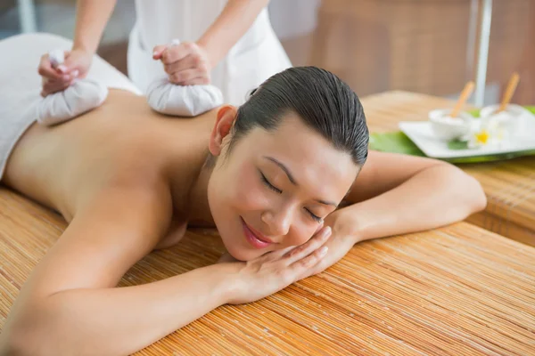 Brunette getting a herbal compress massage