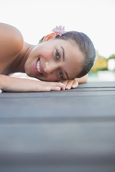 Peaceful brunette lying on towel smiling