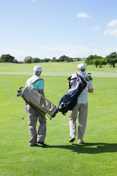 Golfer friends holding their golf bags