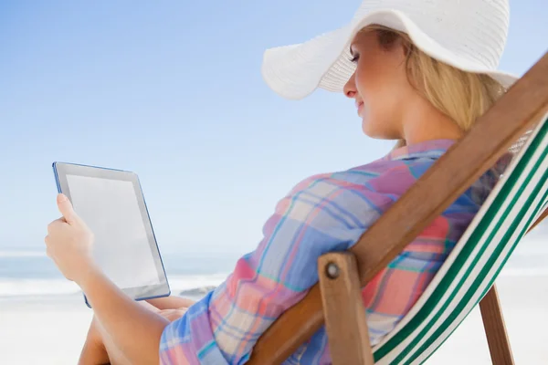 Woman in deck chair using tablet
