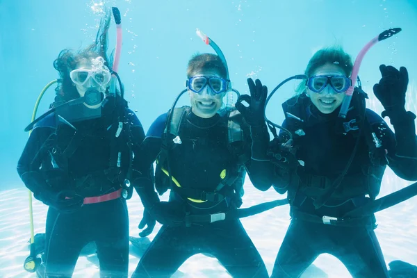 Friends on scuba training submerged in pool