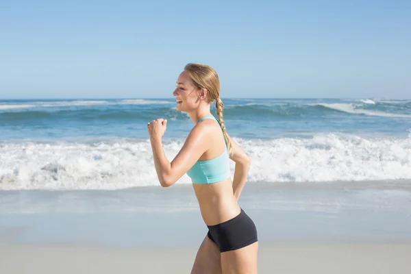 Fit blonde jogging on beach