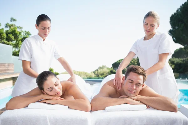 Couple enjoying couples massage poolside