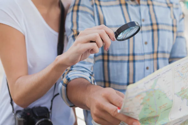 Couple using magnifying glass on the map