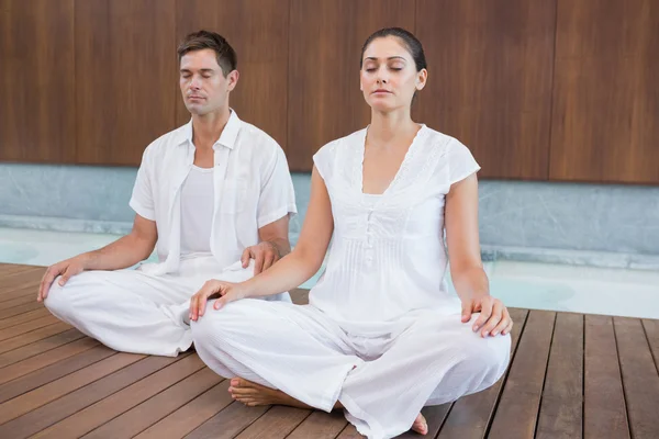 Couple in white sitting in lotus pose