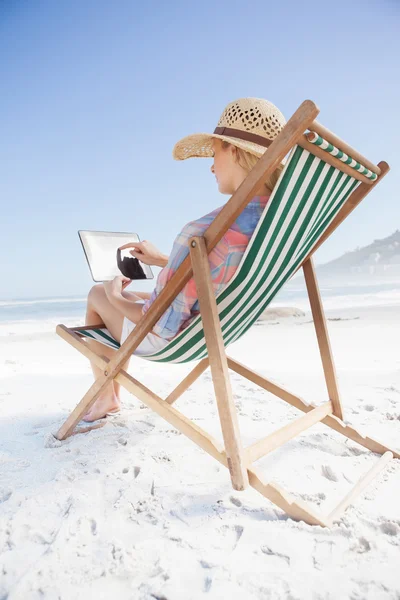 Woman in deck chair using tablet