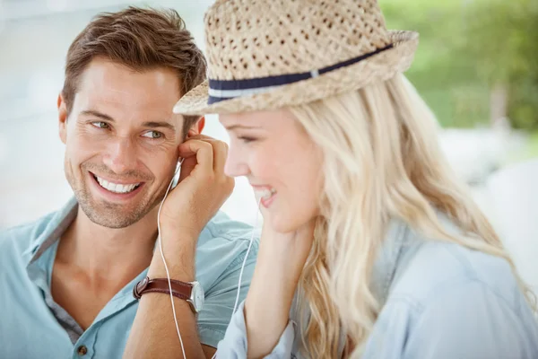 Couple listening to music together in cafe