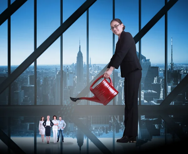 Businesswoman watering tiny business team