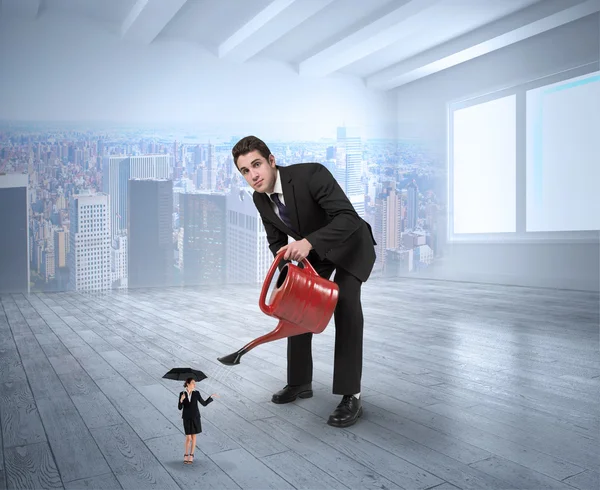 Businessman watering tiny businesswoman