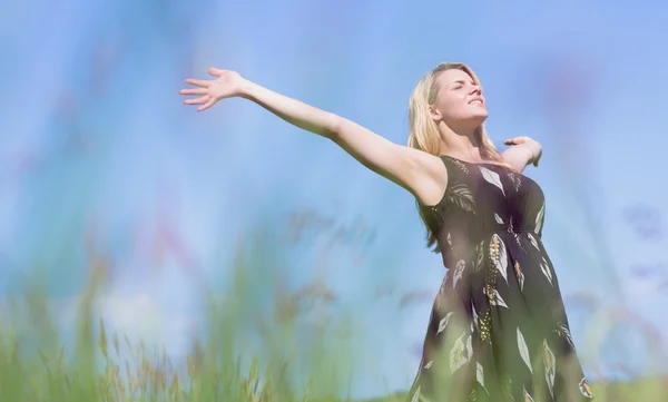 Pretty blonde in sundress standing with arms out