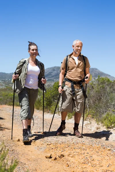 Happy hiking couple walking on mountain trail