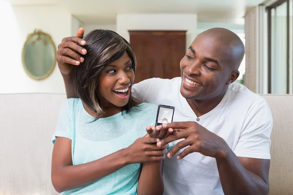 Man surprising his girlfriend with an engagement ring