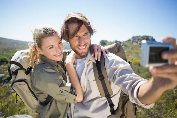 Couple on mountain terrain taking selfie