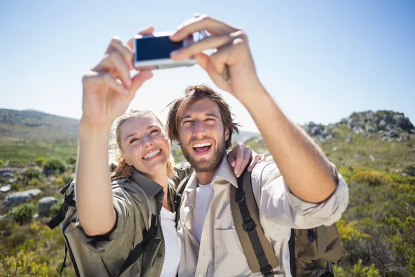 Couple on mountain terrain taking selfie