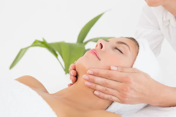 Attractive woman receiving facial massage at spa center