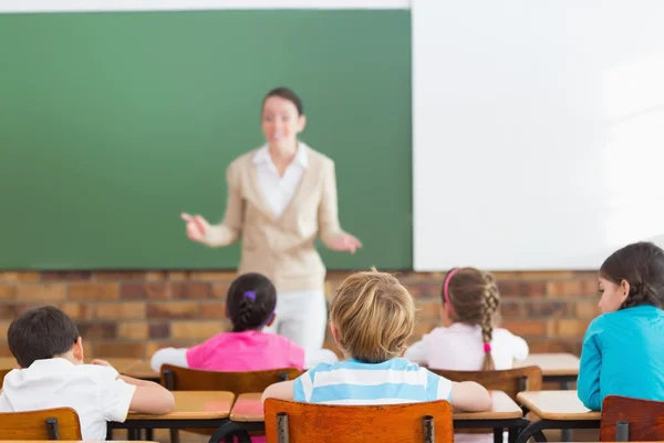 Pupils listening to teacher at chalkboard