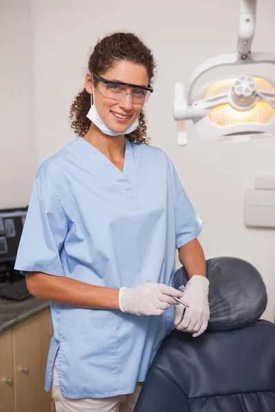 Dentist in blue scrubs smiling