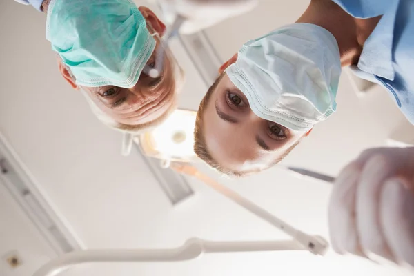 Dentist and assistant leaning over patient