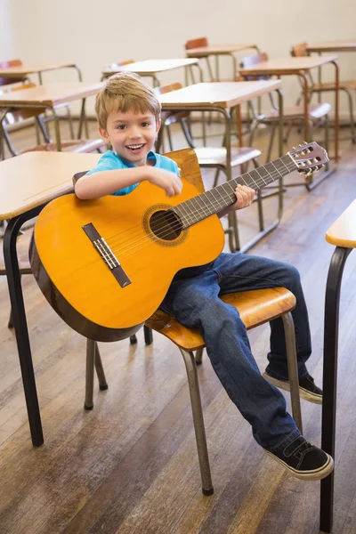 Pupil playing guitar in classroom