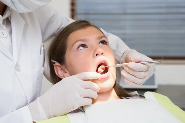 Pediatric dentist examining a little girls teeth