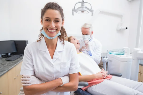 Dental assistant  with dentist and patient