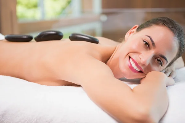 Beautiful woman receiving stone massage at health farm